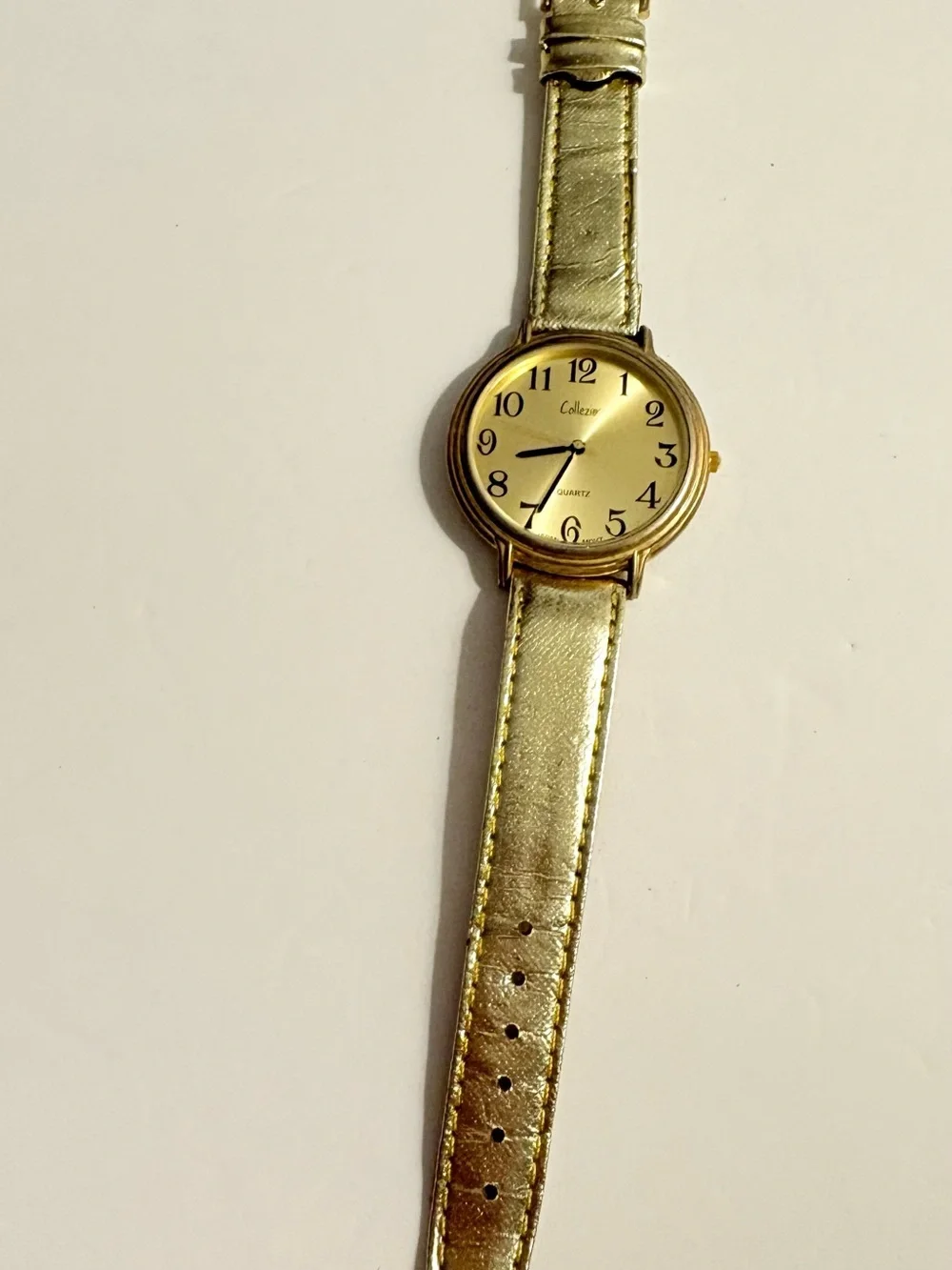 Collezio brand analog wristwatch with a gold dial and synthetic leather strap